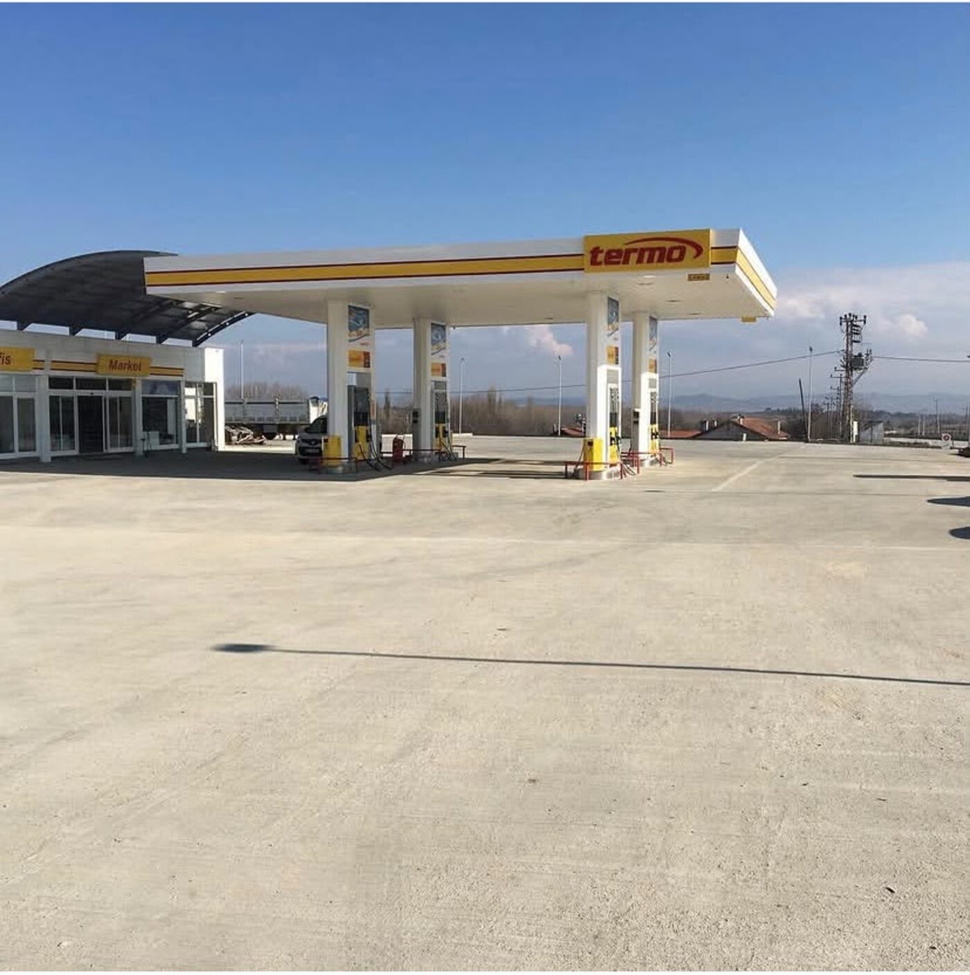 Tesisin akaryakıt istasyonu, market ve geniş beton park alanı