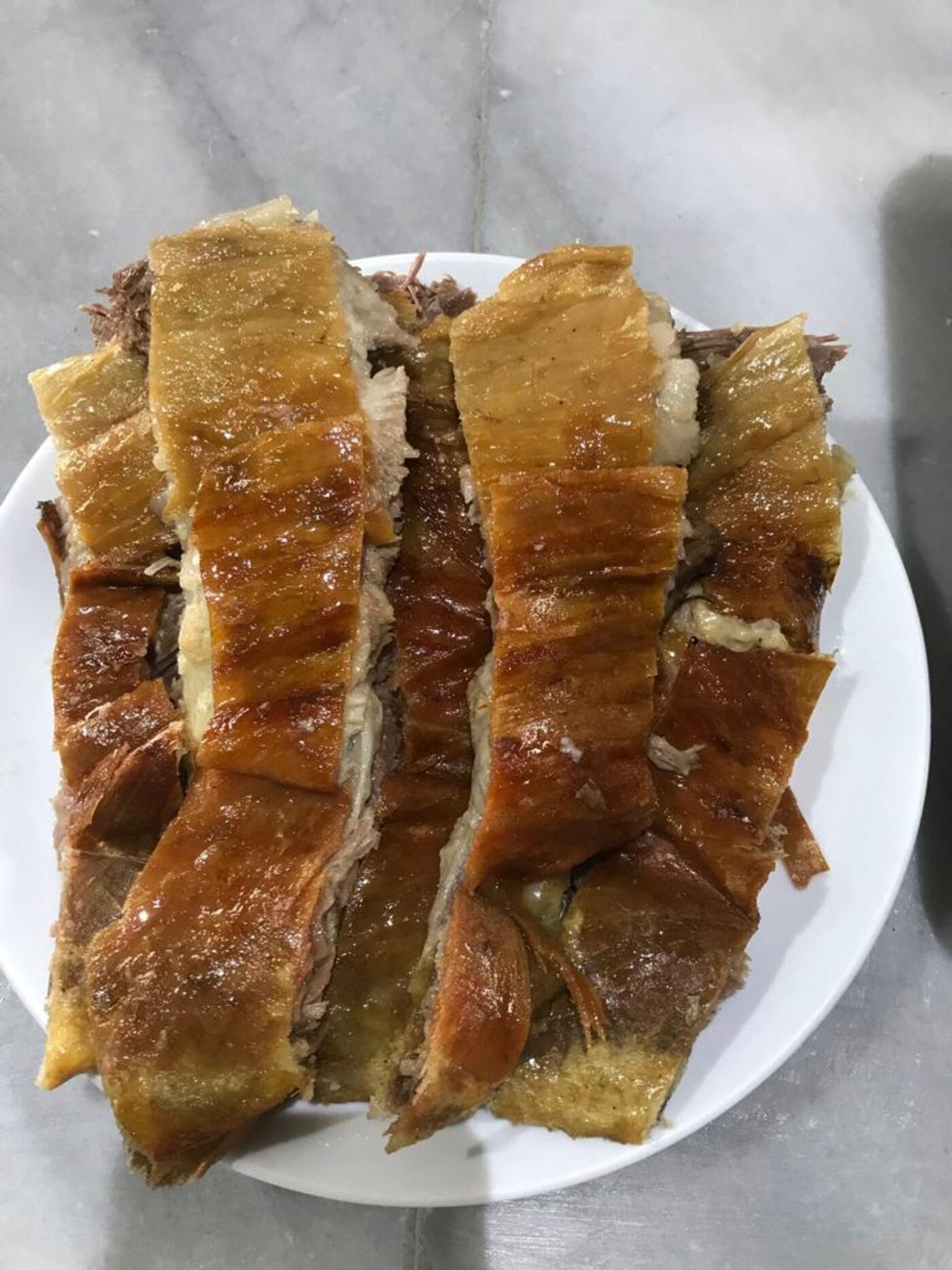 Tabakta dizilmiş, kıtır kabuklu kuyu kebabı dilimleri