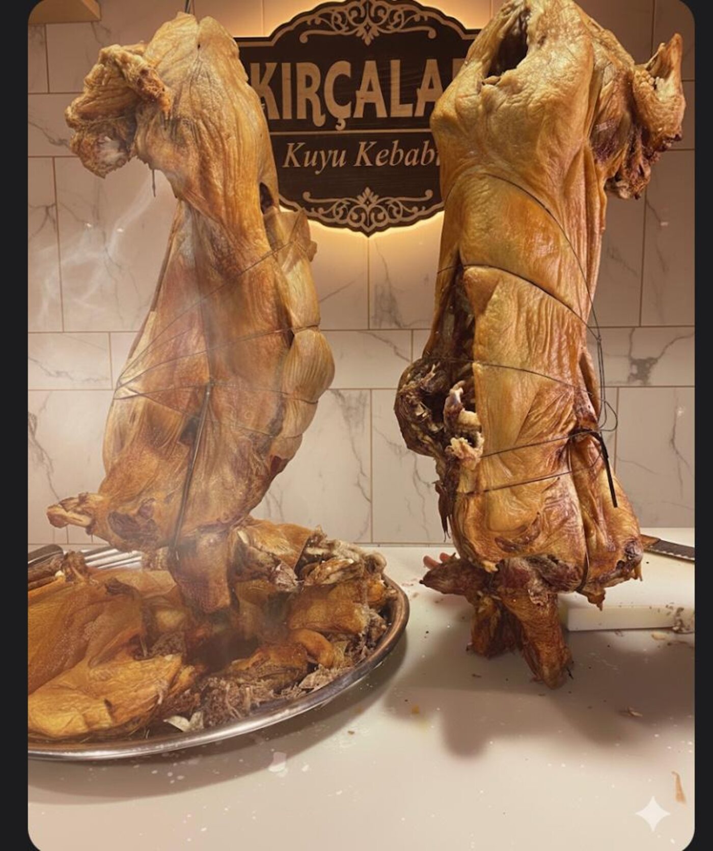 Tabelanın önünde askıda duran kıtır kabuklu kuzular