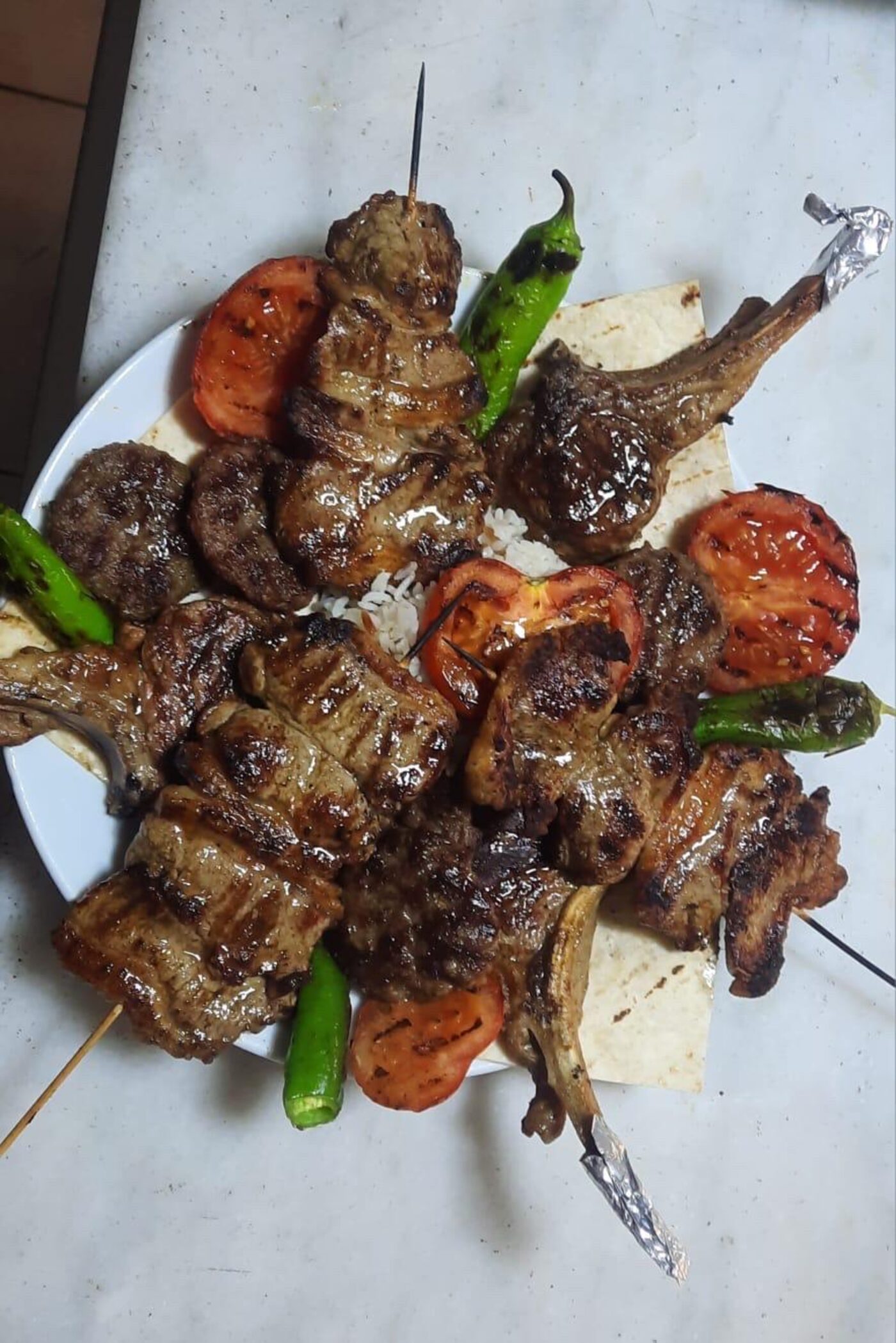 Pirzola, şiş, köfte, közlenmiş domates ve biberden oluşan karışık ızgara tabağı