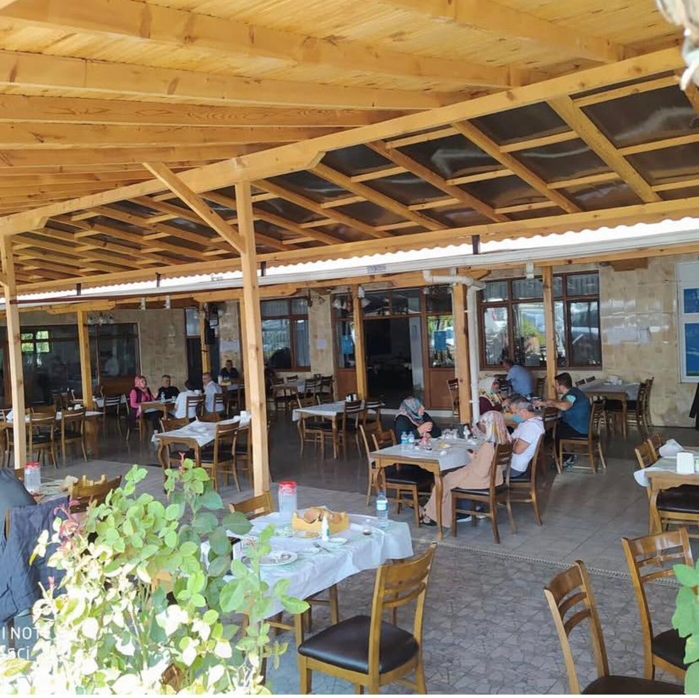 Ahşap tavanlı veranda salonunda oturan misafirler